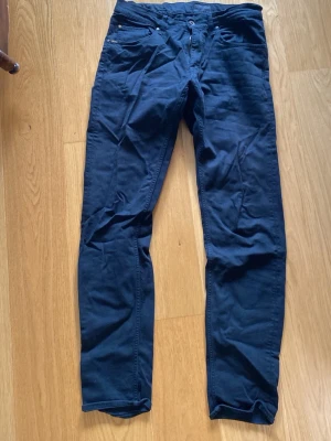 Svarta jeans med smal passform - Snygga svarta jeans med smal passform och klassisk design. Byxorna har framfickor, bälteshällor och knappgylf. Perfekta för en stilren och avslappnad look. Storlek 32/36