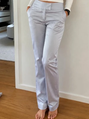 Ljus gråblå satin byxor stl 36 Nya - Ljust gråblå satin byxor från H&M stl 36. Byxor med raka ben och medelhög midja. Byxorna har fickor framtill och baktill. Försluts med dragkedja och hake framtill. Nya. Mkt bra passform.