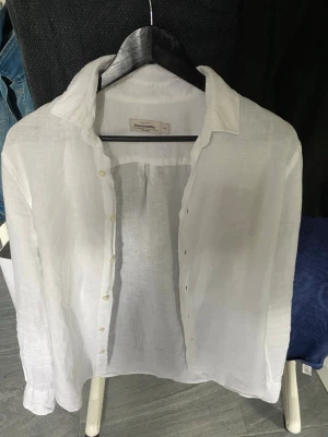 Vit linneskjorta från Dressmann XS - Klassisk vit skjorta från Dressmann i 100% linne. Skjortan har lång ärm, knappar framtill och en avslappnad passform. Perfekt för en clean och fräsch look under varmare dagar.