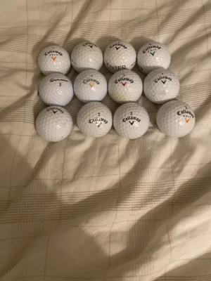 11 vita golfbollar Callaway och en taylormade  - Säljer ett set med 12 vita golfbollar från Callaway. Bollarna har olika nummer och färgade markeringar. Perfekt för dig som vill fylla på golfbagen med kvalitetsbollar. Alla bollar är av standardstorlek och har klassisk dimple-yta.