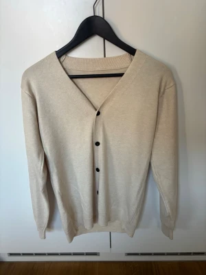 Beige cardigan - En snygg helt oanvänd beige cardigan i stickat material