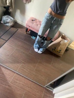 Ljusblå slitna jeans med hål - Säljer ett par ljusblå jeans med raka ben och stora hål över knäna. Jeansen har klassisk femficksmodell och låg midja. Perfekta för en avslappnad och trendig look. Materialet är denim i bomull. Storlek 164