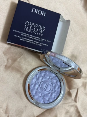 Dior Forever Glow Luminizer Blue Strobe - Highlighter från Dior i nyansen 05 Blue Strobe. Kommer i en lyxig rund silverfärgad dosa med quiltad design och spegel. Pudret har en kall, blåskimrande ton och ger ett spektakulärt glow. Innehåller hyaluronsyra för extra vård.
