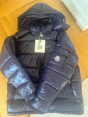 Moncler Maya - Säljer denna snygga Moncler Maya i marinblå färg med storlek M. Aldrig använd skick 10/10. Perfekt inför hösten och vintern nu. Mitt pris 2299kr kan gå ner lite vid snabb affär. Vid intresse eller frågor hör av er!