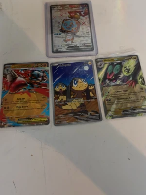 Fyra Pokémonkort blandade motiv - Säljer fyra Pokémonkort med olika motiv, bland annat Noivern GX och andra holografiska och färgglada kort. Korten har klassisk Pokémon-design med detaljerade illustrationer och text. Perfekt för samlare eller dig som gillar Pokémon! ( riktiga! )