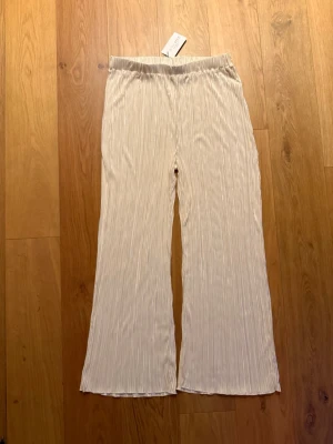 Plisserade Byxor ASOS - Helt Nya - Säljes då jag helt enkelt inte orkat ta tag i att fixa en retur sedan jag provade de! Så de har bara legat i garderoben senaste året. 😝 Som sagt helt nytt skick. Skulle säga att de är stora i storleken. 🌸 Färgen är creme. 😊 Se näst sista bilden för material. Nypris var ca. 500:- 