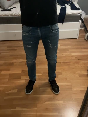 Replay jeans slitningar  - Sjukt snygga replay Anbass jeans med feta slitningar! Storlek 30:32, fint skick. Modellen är 180 cm 66kg, skriv vid frågor! 
