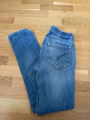 Dondup - Snygga blå dondup jeans i slim fit-modell med klassisk femficksdesign och slitna detaljer på framsidan. Jeansen har normal midja och raka ben. Tillverkade i denim med en tvättad look som ger en avslappnad vibe. Hör av er vid funderingar!