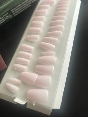 Ljusrosa press-on naglar Switch Nails - Säljer ett set med ljusrosa press-on naglar från Switch Nails. Naglarna har en mjukt rundad form och kommer i flera storlekar för att passa olika nagelbäddar. Materialet är plast och finishen är blank för en fräsch look. Har använt de en gång endast testade på 