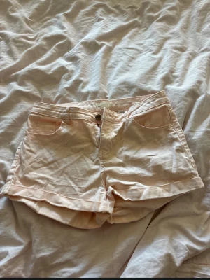 Ljusrosa shorts med dragkedja - Säljer ett par ljusrosa shorts med klassisk femficksdesign och dragkedja framtill. Shortsen har en knapp i midjan och är tillverkade i ett mjukt bomullsmaterial. Perfekta för varma sommardagar! Tycker de verkar lågmidjade men hör av er så fixar jag bild osv 