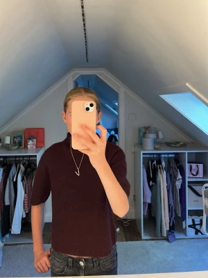 Vinröd stickad tröja med kort ärm - Mysig vinröd stickad tröja med korta ärmar och rund hals. Tröjan har en enkel, rak passform. Materialet är mjukt och bekvämt.