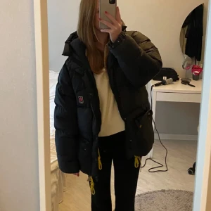 Svart Fjällräven jacka med dustbag - Fjällräven jacka med dustbag, bra skick men lite smutsig högst upp vid kragen men kan försöka få bort det. ( bild 5) Kan skicka mer bilder om det önskas. LÅNAD BILD!