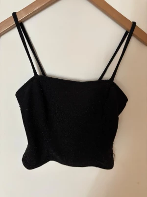 Svart glittrig linnetopp  - Säljer en svart glittrig linnetopp från Gina Tricot. Toppen har smala axelband och croppad passform🖤