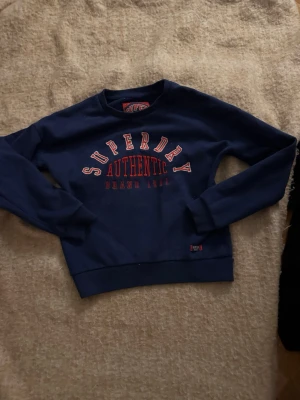 Mörkblå sweatshirt från Superdry - Snygg mörkblå sweatshirt från superdry, i bra skick och jätte bra pass form, passar perfekt till dig som söker nya höst kläder😻😻