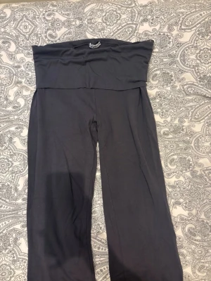 Mörkgrå mjuka loungewear-byxor - Supersköna mörkgrå loungewear-byxor med bred midjeresår och raka ben. Perfekta för att chilla hemma eller mysa runt i. Materialet känns mjukt och stretchigt, vilket gör dem extra bekväma.