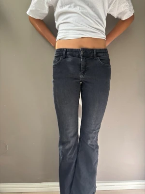 Svarta bootcut jeans - Säljer ett par svarta bootcut jeans med klassisk femficksdesign och normalhög midja. Jeansen har en lätt utsvängd passform nedtill och är tillverkade i ett stretchigt denimtyg för extra komfort. Perfekta för en avslappnad och trendig look. Uppsydda ca 1 cm