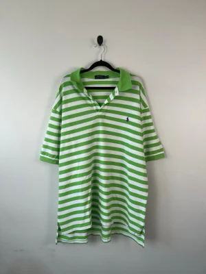 Vintage Polo Ralph Lauren Piké 2XB Big XXL Grön Vit Randig Oversized HerrVintage Polo Ralph Lauren Piké 2XB Big XXL Grön Vit Randig Oversized HerrVintage Polo Ralph Lauren Piké 2XB Big XXL Grön Vit Randig Oversized Herr - • Storlek: XXL • Färg: Ljusgrön + vit • Passform: Relaxed Fit  • Krage: Klassisk pikékrage • Material: 100% bomull  Skick: Plagget är i ett fint skick med två fläckar som syns på bild. Eventuella anmärkningar anges alltid tydligt i beskrivningen och visas på bilderna.  Nypris: Cirka 1 300 kr.  📦 Skickas snabbt och packas omsorgsfullt. 💬 Hör gärna av dig om du har frågor eller vill se fler bilder. 🤝 Samfrakt erbjuds vid köp av flera plagg – kika gärna in mina andra annonser!• Storlek: XXL • Färg: