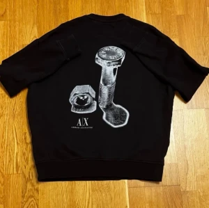 Armani Exchange Tröja - Snygg svart sweatshirt från Armani Exchange med unikt silvertryck. Loose fit, passar även Medium. Sparsamt använd och i superbra skick, inga skador.