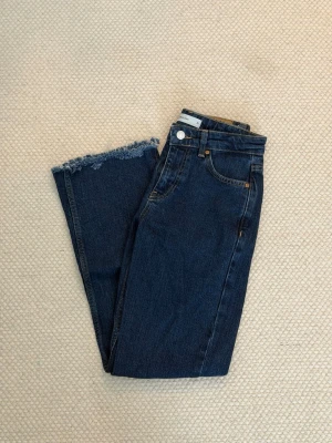 Full length flare petite jeans - Säljer ett par blåa full length flare petite jeans från Gina tricot i storlek 32. De är avklippta till en innerbenslängd på ca 68-70cm. Använda en gång.