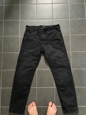 Svarta raka jeans - Säljer ett par svarta jeans med rak passform och klassisk femficksdesign. Jeansen har normal midja och är tillverkade i ett kraftigt denimtyg. Perfekta för dig som gillar en enkel och stilren look.