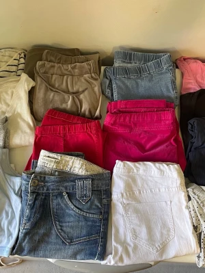 Klädpaket dam/tjej storlek M - Säljer ett gäng byxor och jeans i olika färger och modeller. Här finns blå jeans, vita byxor, två par knallrosa byxor, ljusblå jeans och flera par i beige och brunt. Perfekt för dig som vill ha variation i garderoben! Total 17 plagg 