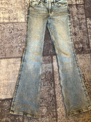 Ljusblå bootcut jeans - Endast upphämtning ❤️ Säljer ett par ljusblå bootcut jeans med klassisk femficksmodell och utsvängda ben. Jeansen har en snygg tvättad look och normal midja. Perfekta för dig som gillar retrostil och vill ha ett par bekväma jeans med lite extra attityd.