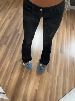 Svarta bootcut jeans med låg midja - Säljer ett par svarta bootcut jeans med låg midja och klassisk femficksmodell. Jeansen har en snygg tvätt och raka ben som går ut lite nedtill. Perfekta till en trendig och avslappnad stil. LÅNGA!!! Passar mig som är 174