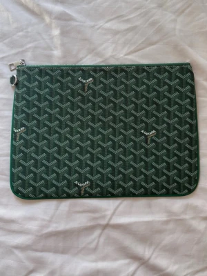 Grön handväska  - Snygg grön handväska med ett klassiskt mönster i vitt och grönt. Perfekt för att bära din ipad eller liknande med stil.