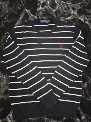 Polo Ralph Lauren Unisex Striped Crewneck Sweater 100% Pima Cotton (Size L) - Classic Polo Ralph Lauren striped crewneck jumper in navy blue and white, featuring the iconic red pony logo embroidered on the chest. Unisex style, perfect for anyone! Brand: Polo Ralph Lauren Size: L Material: 100% Pima Cotton (premium quality, super soft) Condition: Excellent condition Fit: Unisex Measurements:  •Length: 67 cm  •Shoulder width: 47 cm (very stretchy material) Fast shipping guaranteed!