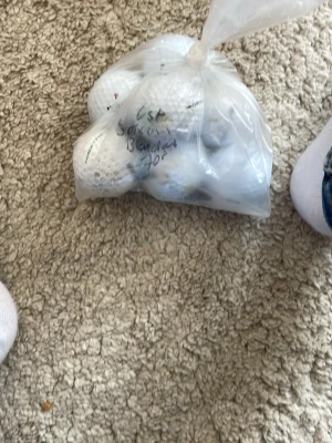 Påse med vita golfbollar - Säljer en plastpåse fylld med flera vita golfbollar. Perfekt för dig som vill fylla på golfutrustningen eller öva på rangen. Bollarna är av standardstorlek och ligger i en genomskinlig plastpåse.