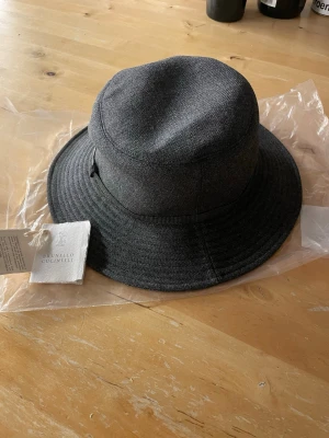 Brunello Cucinelli Hat - Stilren mörkgrå bucket hat från Brunello Cucinelli, Ny och Oanvänd i storlek M.