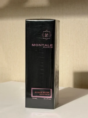 Montale Roses Musk Eau de Parfum - Montale Roses Musk Eau de Parfum är en lyxig parfym i svart rektangulär förpackning med rosa detaljer. Doften kombinerar ros och mysk för en elegant och modern känsla. Flaskan rymmer 100 ml och har en stilren design som passar perfekt på parfymhyllan.