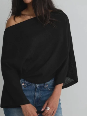 Svart offshoulder topp - Säljer en svart offshoulder topp med lång ärm och avslappnad passform. Toppen har en snygg, asymmetrisk skärning som ger en cool look och är tillverkad i ett mjukt, stickat material. Perfekt att styla med jeans eller kjol.