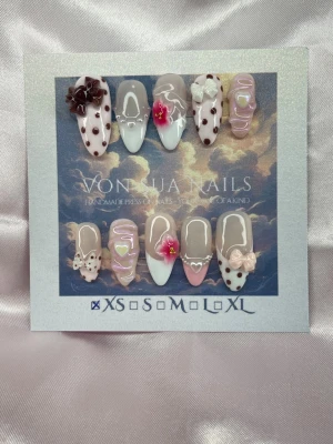 Alba (XS);Medium Almond - Handgjorda press-on naglar i en medium lång mandelform med mix av ljusrosa, vitt och brunt. Dekorerade med bruna prickar, 3D-rosetter, blommor och hjärtan. Naglarna har glansig finish och detaljer i akryl för en unik look.XS: 14 mm, 11 mm, 11,5 mm, 10 mm, 8 mm