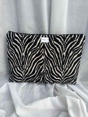 Datorfodral zebra  - Snyggt datorfodral i snyggt zebratyg. Innertyg i brun och en matchande svart dragkedja. Passar perfekt för laptop och tillhörande sladd eller anteckningsbok. Passar laptop med maxmått: 32x24cm