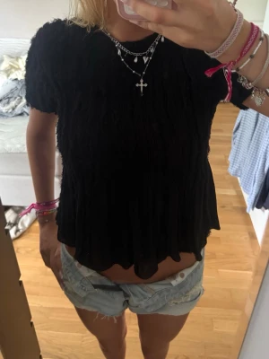 Svart blus topp från Zara💕 - Säljer en svart topp från Zara i storlek S. Toppen har rynkad struktur, korta ärmar och vågig nederkant. Materialet är lätt och luftig, perfekt för sommaren. Enkel att matcha med både jeans och kjol.💖