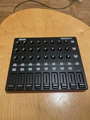 Akai MIDIMIX MIDI-Professional - Säljer en Akai MIDIMIX MIDI-kontroller med svart ovansida och röd undersida. Den har 8 faders, 24 rattar och flera knappar för mixning och kontroll av ljud. Perfekt för musikproduktion och live-mixning. Kompakt och lätt att ta med.