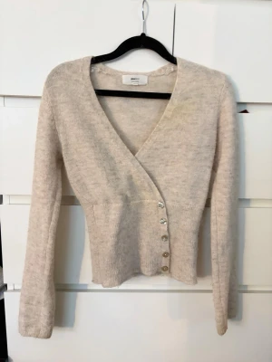 Beige kofta från Gina Tricot XS - Mysig beige kofta från Gina Tricot i alpackablandning. Har använt fåtal gånger så väldigt fint skick. 
