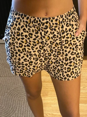 Leopardmönstrade shorts med resår - Snygga shorts med leopardmönster i beige, svart och brunt. De har elastisk midja och sidofickor med mjukt och lätt material. Shortsen har inte kommit till användning för mig.