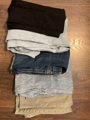Mix av jeans och byxor i olika färger  - Säljer ett gäng byxor och jeans i olika färger och material. Här finns svarta, ljusblå, mörkblå, grå och gröna byxor, både i denim och mjukare tyg. Perfekt för dig som vill uppdatera garderoben med flera stilar och färger. Från märkena gina tricot, nelly och lager 157!