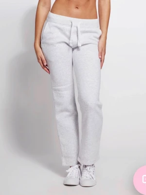 Gråa russemerch byxor - Säljer ett par ljusgrå mjukisbyxor med raka ben och dragsko i midjan. Byxorna har fickor på sidorna och är tillverkade i ett mjukt och bekvämt sweatmaterial. Perfekta för chill dagar eller när du vill vara extra comfy. Säljer pga att jag växt ut dem i längden
