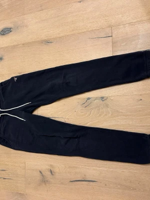 Svarta mjukisbyxor från GANT - Säljer ett par marin blå mjukisbyxor från GANT med broderad logga på höften. Byxorna är tillverkade i mjukt bomullsmaterial. Perfekta för chill dagar eller när du vill vara extra bekväm. Passar för män med längden 170cm ungefär.