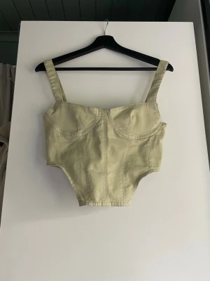 Ljusgrön body med breda axelband - Trendig ljusgrön body med breda axelband och markerade sömmar. Bodyn har bygelinspirerad kupa och är tillverkad i ett mjukt, stretchigt tyg som formar sig efter kroppen. Perfekt för att skapa en cool och modern look.
