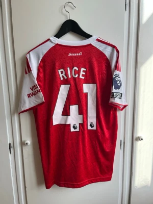 Arsenal 2025/26 Hemmatröja - Declan Rice - Arsenals hemmatröja säsongen 25/26 med Declan Rice på ryggen. Storlek M, Ny med lapparna kvar! Hör av dig om du vill ha fler bilder!