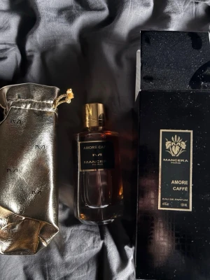 Mancera Amore Caffè Eau de Parfum 120ml - Lyxig parfym från Mancera, Amore Caffè, i en elegant mörk glasflaska med guldfärgat lock. Kommer med en exklusiv guldfärgad påse och svart förpackning. Doften är intensiv och unik, perfekt för dig som vill sticka ut.