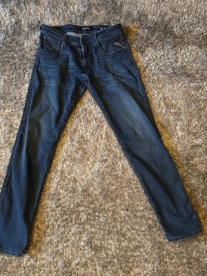 Mörkblå jeans från Replay, W30 - Säljer ett par mörkblå jeans från Replay i klassisk rak modell. Jeansen har fem fickor, snygga slitningar och är tillverkade i bomull med lite stretch för extra komfort. Perfekta för dig som gillar en tidlös och clean look. Storlek W30 L30 använda en gång i min ägo dem har bara legat i min garderob sen 3 år tillbaka ungefär därav säljes 