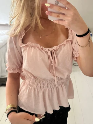 Ljusrosa blus med knyt och volang - Jättegullig rosa blus säljer så den är lite stor på mig💓