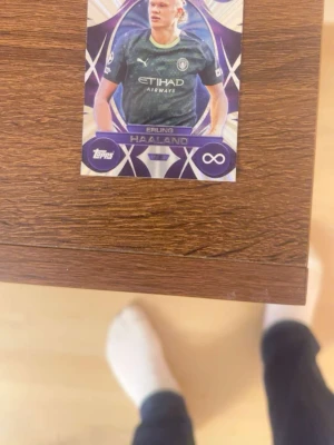 Topps fotbollskort Erling Haaland - Säljer ett samlarkort från Topps med Erling Haaland i Manchester Citys matchtröja. Kortet har lila och vita detaljer samt infinity-symbol. Perfekt för dig som gillar fotboll och samlar på sportkort.