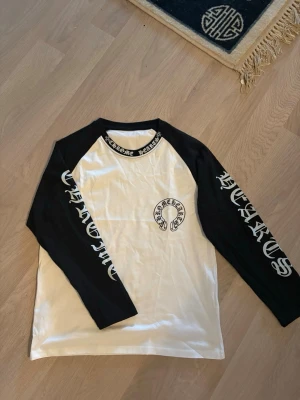 Chrome Hearts långärmad tröja - Säljer en långärmad tröja från Chrome Hearts. Tryck på både fram och baksida, samt vid bröstet, armarna och halsrigningen. Svart och vitfärgad.  Super fint skick helt som ny. Obs! Detta är en unisex modell (ganska korta armar) så man är uppmärksam om det!🙂