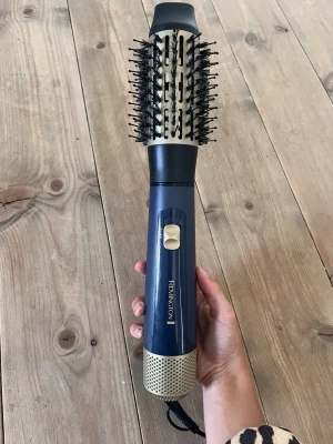 Remington varmluftsborste blå - Säljer en blå varmluftsborste från Remington med rund borste och svarta borststrån.  Perfekt för att styla håret och skapa volym. Knappt använd. 